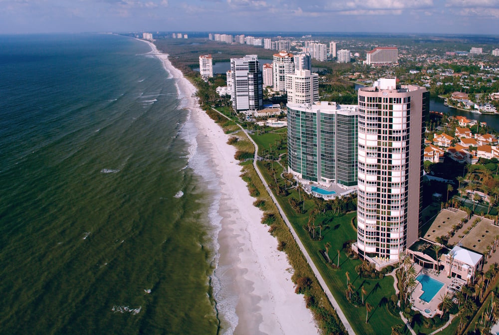 Aerial view of Gulf-front high-rises and turquoise water along Naples' coastline